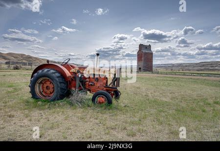 Vieux tracteur et élévateur à grain dans la ville de Dorothy, dans les terrains de l'Alberta, près de Drumheller Banque D'Images