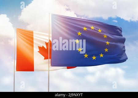 Ciel bleu ensoleillé et drapeaux de l'Union européenne et du canada Banque D'Images