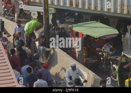 24 mai 2022, Lahore, Punjab, Pakistan : Les navetteurs pakistanais tentent de traverser un pont au-dessus de la rivière Ravi le long d'une route partiellement bloquée par des conteneurs par les autorités locales pour empêcher la mobilité en amont du sit-in prévu à Islamabad par le Pakistan Tehreek-e-Insaf (PTI), l'ancien Premier ministre pakistanais Imran Khan à Lahore. Le principal parti d'opposition du Pakistan, dirigé par le Premier ministre récemment évincé, Imran Khan, a accusé la police d'avoir arrêté des centaines de ses partisans dans des raids qui ont commencé mardi en prévision d'un important sit-in prévu par l'ancien dirigeant, les membres de haut rang du parti et la police Banque D'Images