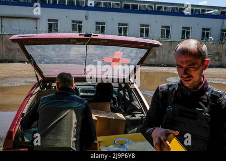 Des volontaires chargent une voiture avec des boîtes de nourriture et de médicaments en dehors du centre de distribution de l'aide humanitaire de la ville. Severodonetsk, la plus grande ville sous contrôle ukrainien de la province de Luhansk, a été soumise à une artillerie intense et à des tirs de missiles de l'armée russe. La ville est presque isolée par le reste de la région, il y a une route principale reliant la ville à Kramatorsk, l'armée russe essaie de l'occuper et du contrôler pour couper les provisions et les approvisionnements à la ville. Les experts militaires suggèrent la possibilité que Severodonetsk tombe en état de siège selon le scénario de Marioupol. Banque D'Images