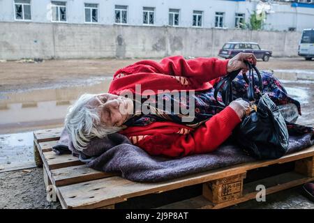 23 mai 2022, Severodonetsk, Ukraine : une femme blessée pose sur une palette en bois à l'entrée du centre de distribution de l'aide humanitaire de la ville. Severodonetsk, la plus grande ville sous contrôle ukrainien de la province de Luhansk, a été soumise à une artillerie intense et à des tirs de missiles de l'armée russe. La ville est presque isolée par le reste de la région, il y a une route principale reliant la ville à Kramatorsk, l'armée russe essaie de l'occuper et du contrôler pour couper les provisions et les approvisionnements à la ville. Selon les experts militaires, il est possible que Severodonetsk tombe en état de siège Banque D'Images