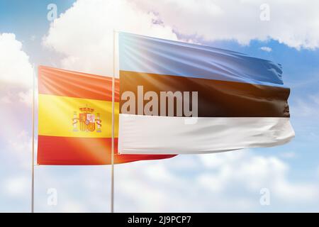 Ciel bleu ensoleillé et drapeaux de l'estonie et de l'espagne Banque D'Images