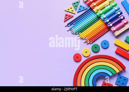 Jouets éducatifs avec crayons sur fond lilas Banque D'Images