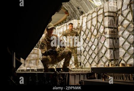 Le capitaine Airman Jolan Besse, commandant de répartition de l'escadron aérien 721st, aide les aviateurs à charger des préparations pour nourrissons sur un avion C-17 Globemaster lll affecté à la base conjointe Pearl Harbour-Hickam, à Hawaï, à la base aérienne de Ramstein, en Allemagne, le 22 mai 2022. La préparation pour nourrissons est arrivée de Suisse dans le cadre de l’opération Fly Formula du gouvernement des États-Unis pour transporter rapidement la préparation pour nourrissons aux États-Unis en raison de pénuries importantes dans ce pays. Dans le cadre de l'opération Fly Formula, l'USDA et le ministère de la Santé et des Services sociaux sont autorisés à demander le soutien du ministère de la Défense pour ramasser des bébés à l'étranger Banque D'Images