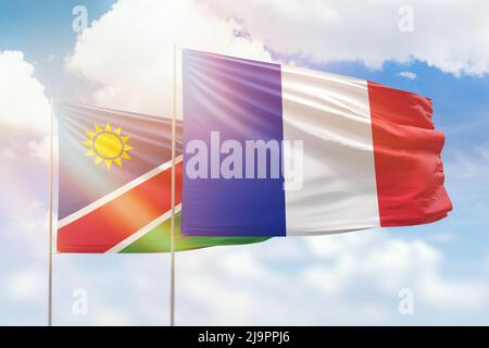 Ciel bleu ensoleillé et drapeaux de la france et de la namibie Banque D'Images