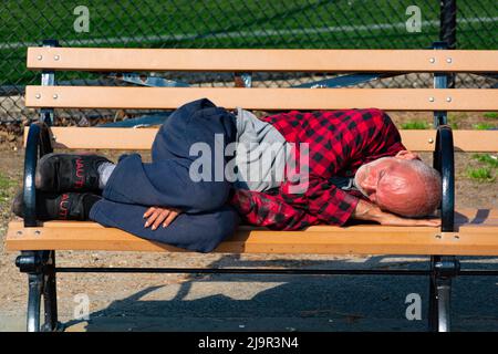 Un homme ivre dort sur le banc à Brooklyn Banque D'Images