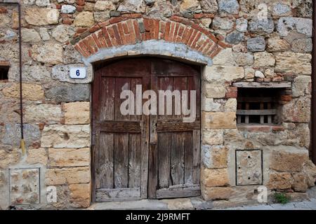 Italie, Toscane, Monteriggioni. Ancienne porte et mur en pierre dans la ville fortifiée de Monteriggioni. Banque D'Images