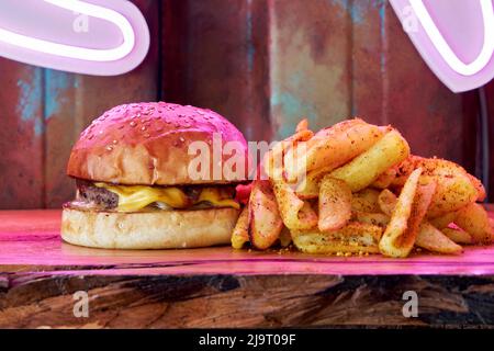 Un hamburger, un hamburger ou un cheeseburger sur une assiette en bois avec des frites frites de pommes de terre frites. Banque D'Images