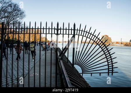 États-Unis, New York City, Manhattan, Upper East Side. John Finley promenade le long de East River, réseau de fer en face de la rivière Banque D'Images