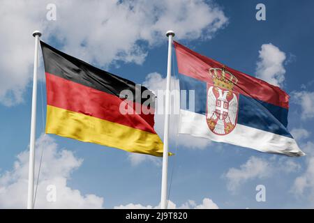 Allemagne et Serbie deux drapeaux sur les mâts et fond bleu ciel nuageux Banque D'Images