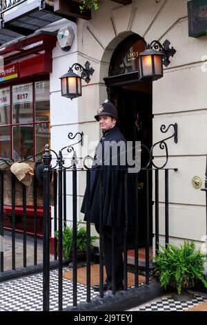 LONDRES, GRANDE-BRETAGNE - 11 MAI 2014 : artiste-policier à l'entrée du musée Sherlock Holmes sur Baker Street 221B. Banque D'Images