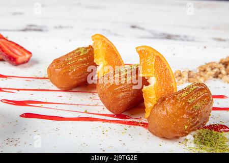 Dessert turc traditionnel tulumba, tulumba tatlisi dans une assiette servie avec du thé. Tulumba (ou Bamiyeh), dessert turc populaire dans la cuisine ottomane. Banque D'Images