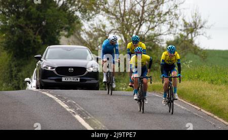 Groupe de cyclistes avec ligne de voitures derrière Banque D'Images