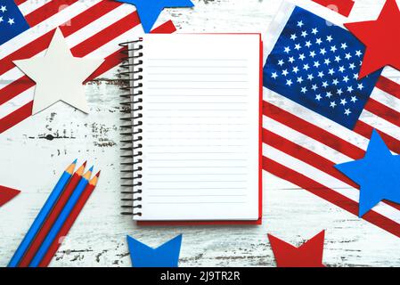 Joyeux jour de l'indépendance le 4th juillet. Vue de dessus du carnet, drapeaux américains, étoiles et crayons avec espace pour le texte sur fond rustique en bois blanc Banque D'Images