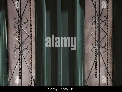 Ancienne maison néoclassique porte d'entrée en bois vert cyprès avec grilles en fer forgé fabriquées à la main et rideaux en métal blanc fait main. Banque D'Images