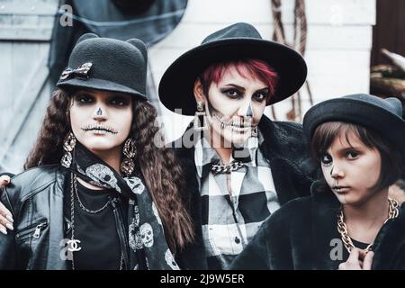 Famille, mère et fille effrayantes célébrant halloween. Des costumes de sorcière et de maquillage noir et blanc terrifiants, des images élégantes. Horreur, amusement a Banque D'Images