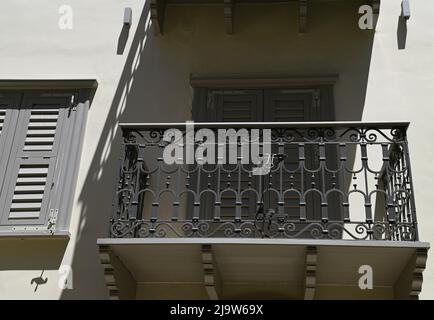 Ancienne façade de maison néoclassique avec volets en bois gris et balcon avec une main courante en fer forgé. Banque D'Images