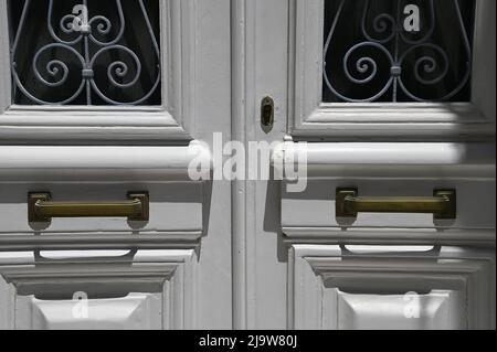 Ancienne maison néoclassique entrée avant porte en bois avec grilles en fer forgé fabriquées à la main et poignées anciennes en laiton. Banque D'Images