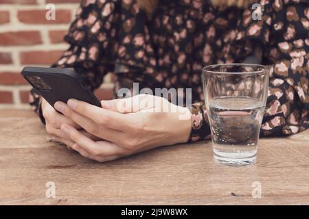 Gros plan des mains des femmes tenant téléphone cellulaire avec espace de copie vierge cri pour message texte ou contenu promotionnel, hipster fille regardant la vidéo sur téléphone mobile pendant une pause dans un café. Photo de haute qualité Banque D'Images