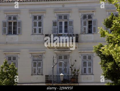 Ancienne maison néoclassique avec des volets en bois gris, balcon avec une main courante en fer forgé et un ancien toit en tuiles d'argile à Nafplio Grèce. Banque D'Images