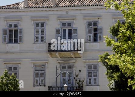 Ancienne maison néoclassique avec des volets en bois gris, balcon avec une main courante en fer forgé et un ancien toit en tuiles d'argile à Nafplio Grèce. Banque D'Images