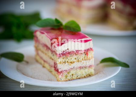 gâteau de pavot à la fraise avec crème dans une assiette sur une table en bois clair Banque D'Images