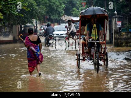 Guwahati, Assam, Inde. 25th mai 2022. Les navetteurs traversent une rue inondée après de fortes pluies, à Guwahati, Assam, Inde, le 25 mai 2022. L'engorgement est une scène courante dans la ville de Guwahati en raison d'un système de drainage médiocre. Crédit : David Talukdar/Alay Live News Banque D'Images