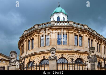 OXFORD ENGLAND BROAD STREET À L'EXTÉRIEUR DES SHELDONIAN TROIS BUSTES SCULPTÉS OU DES TÊTES DES HERMS OU DES EMPEREURS Banque D'Images