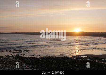 Le soleil descendant sur le bord ouest.Sun set et surfeurs à Lahinch dans l'ouest de l'Irlande. Banque D'Images