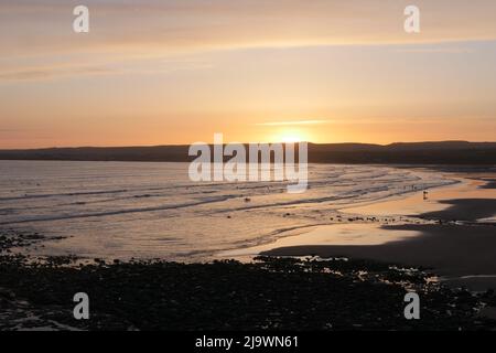 Le soleil descendant sur le bord ouest.Sun set et surfeurs à Lahinch dans l'ouest de l'Irlande. Banque D'Images