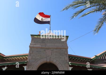 le drapeau égyptien flotte sur l'ancien bâtiment d'assouan Banque D'Images
