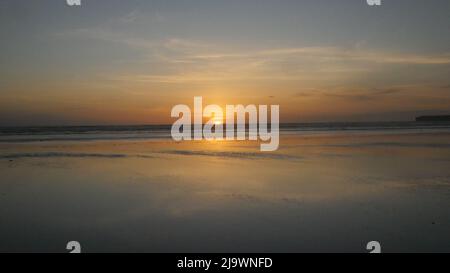 Le soleil descendant sur le bord ouest.Sun set et surfeurs à Lahinch dans l'ouest de l'Irlande. Banque D'Images