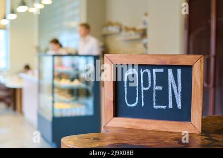 Gros plan de bois avec panneau ouvert écrit par craie sur la table dans le café-restaurant Banque D'Images