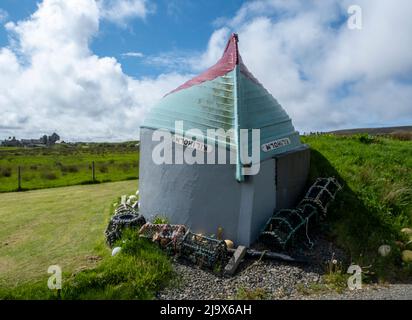 Construction de hangar à bateaux originaux, île de Rousay utilisant un bateau de pêche retourné comme toit pour un bâtiment avec vue sur Wyre Sound, Orkney, Écosse. Banque D'Images