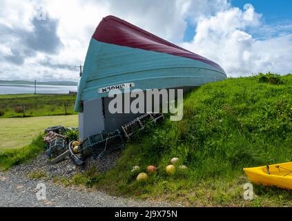 Construction de hangar à bateaux originaux, île de Rousay utilisant un bateau de pêche retourné comme toit pour un bâtiment avec vue sur Wyre Sound, Orkney, Écosse. Banque D'Images