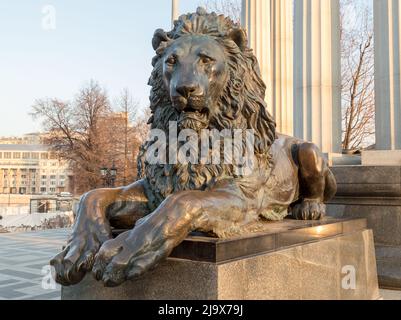 La statue de lion en métal repose sur un piédestal en pierre Banque D'Images