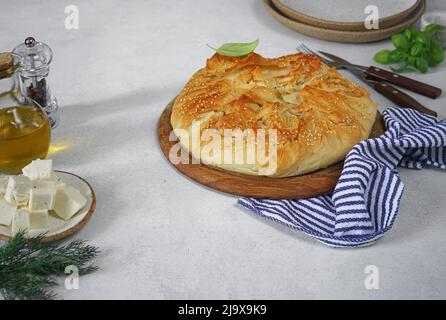 tarte délicieuse au fromage feta aux épinards ou spanakopita sur un bureau en bois, table blanche, recette authentique, ingrédients, espace de copie Banque D'Images