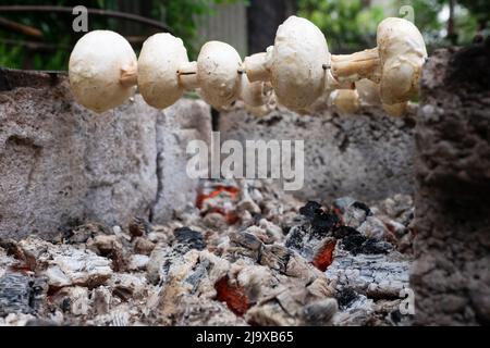 Préparation des champignons sur des charbons en feu. Barbecue pour végétariens. Banque D'Images