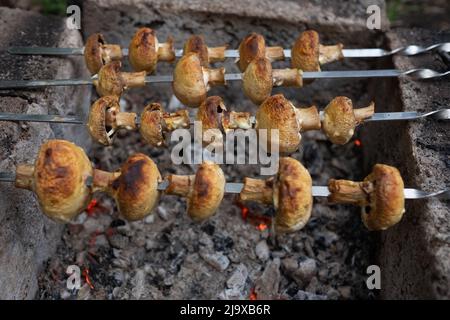 Préparation des champignons sur des charbons en feu. Barbecue pour végétariens. Banque D'Images