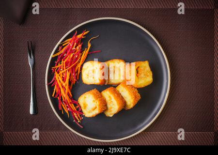Assiette de petits pains à sushis japonais avec des petits pains au thon, au crabe, au saumon, à l'anguille et au gratin, sur une table fine Banque D'Images