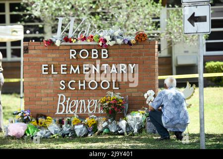 Uvalde, États-Unis. 25th mai 2022. Un résident local place des fleurs à l'extérieur de l'école élémentaire Robb à Uvalde, où un homme seul a tué 19 écoliers et 2 enseignants le 24 mai 2022 crédit: Bob Daemmrich/Alamy Live News Banque D'Images