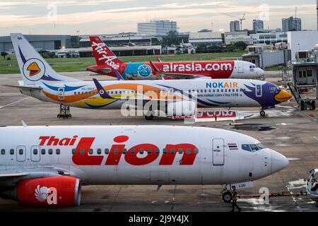 Les Airbus A320-200 commerciaux pour Thai AirAsia (FD), NokAir et Thai Lion sont stationnés devant les portes d'embarquement nationales à l'aéroport international Don Mueang (DMK) de Bangkok. Les voyages internationaux en Thaïlande et le tourisme domestique dans le pays reprennent à mesure que le gouvernement thaïlandais soulage les exigences d'entrée dans le cadre de son programme de passe Thaïlande, permettant aux voyageurs internationaux d'entrer dans le pays sans un test PCR rapide pour le COVID-19 ou la quarantaine à leur arrivée. Le gouvernement thaïlandais a également signalé que l'obligation de porter des masques à l'extérieur devrait se terminer à la mi-juin 2022. Banque D'Images
