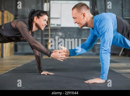 Couple sportif qui fait des repoussez ensemble et donne vife. Gros plan. Concept de travail d'équipe et de mode de vie sain. Banque D'Images