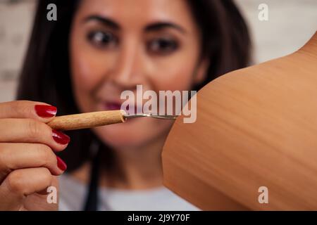 Belle potter maître femme moules de pot d'argile en mai. Femelle étudiant sculpteur travaille avec l'argile sur une roue de potier et à la table avec le Banque D'Images