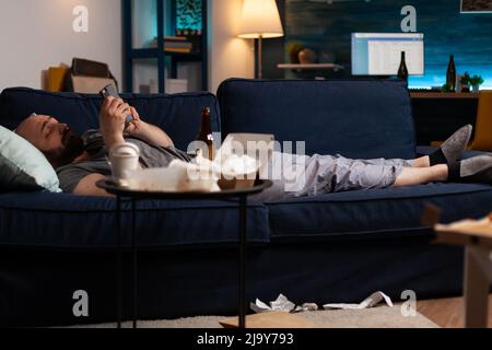 Triste malheureux désespéré désespéré anxiété choquée homme naviguant sur smartphone, luttant avec la santé mentale passant par une dépression majeure de solitude. Frustré, contrarié, un homme a lu des factures numériques non payées Banque D'Images