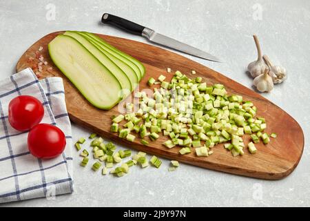 Tranches de légumes de courgettes sur une planche à découper en bois, tomates et ail Banque D'Images