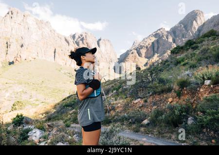 Vue latérale d'une jeune femme qui regarde sur la colline avant de monter Banque D'Images