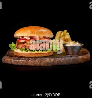 Vue rapprochée de délicieux hamburgers de bœuf frais et de frites sur un plateau en bois Banque D'Images