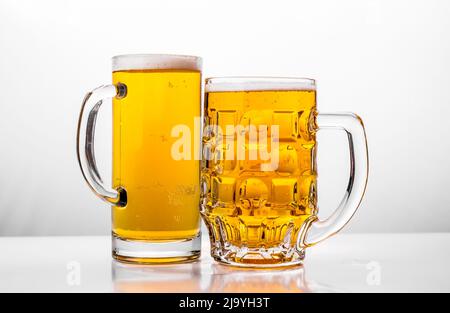 Deux chopes de bière fraîche à l'aide de la mousse. Banque D'Images
