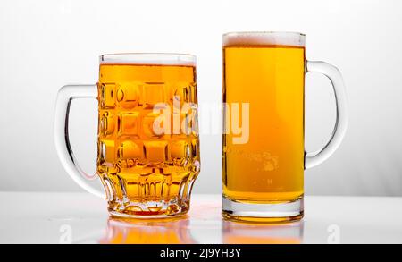 Deux chopes de bière fraîche à l'aide de la mousse. Banque D'Images
